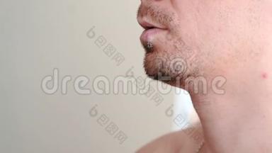 疱疹。 嘴唇治疗。 男人嘴唇的特写`嘴唇上有疱疹和奶油。 前景。